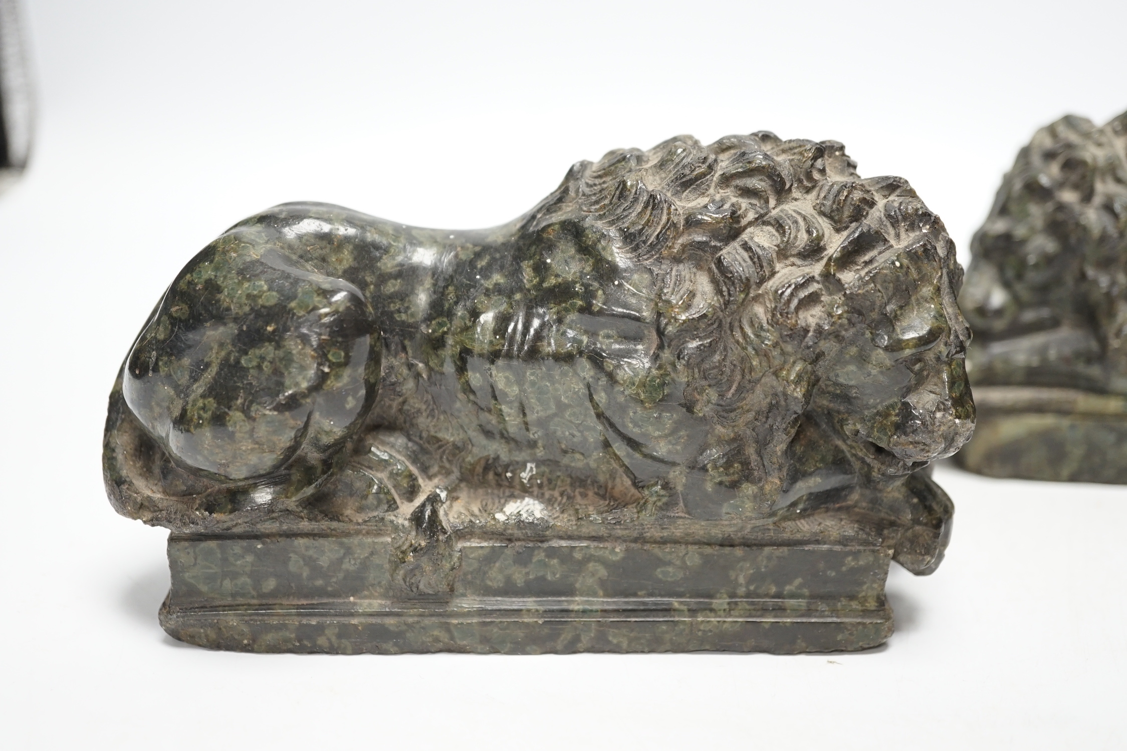 A pair of carved serpentine models of the Lucerne lions, 16cm wide